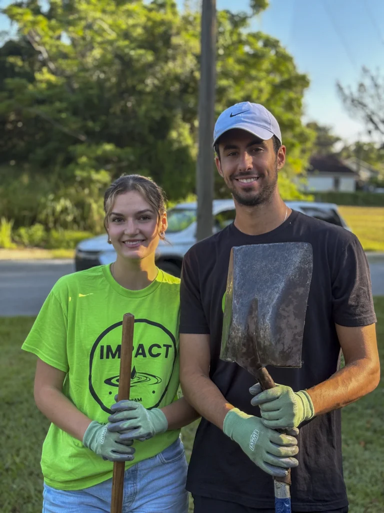 Two volunteers holding shovels and smiling after a Bartow CRA community cleanup event