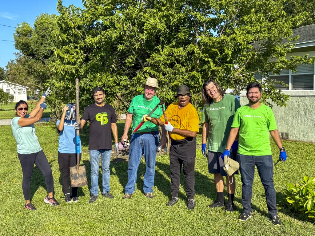 Group of volunteers holding shovels and yard tools at a Bartow community beautification event