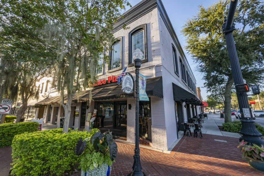 Downtown Bartow building with an ornate wall clock mounted on the corner facade and black awnings