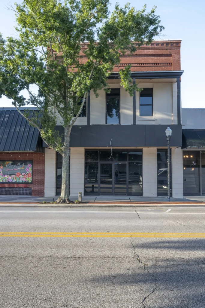 Modern black and white storefront building in downtown Bartow with an orange upper facade trim