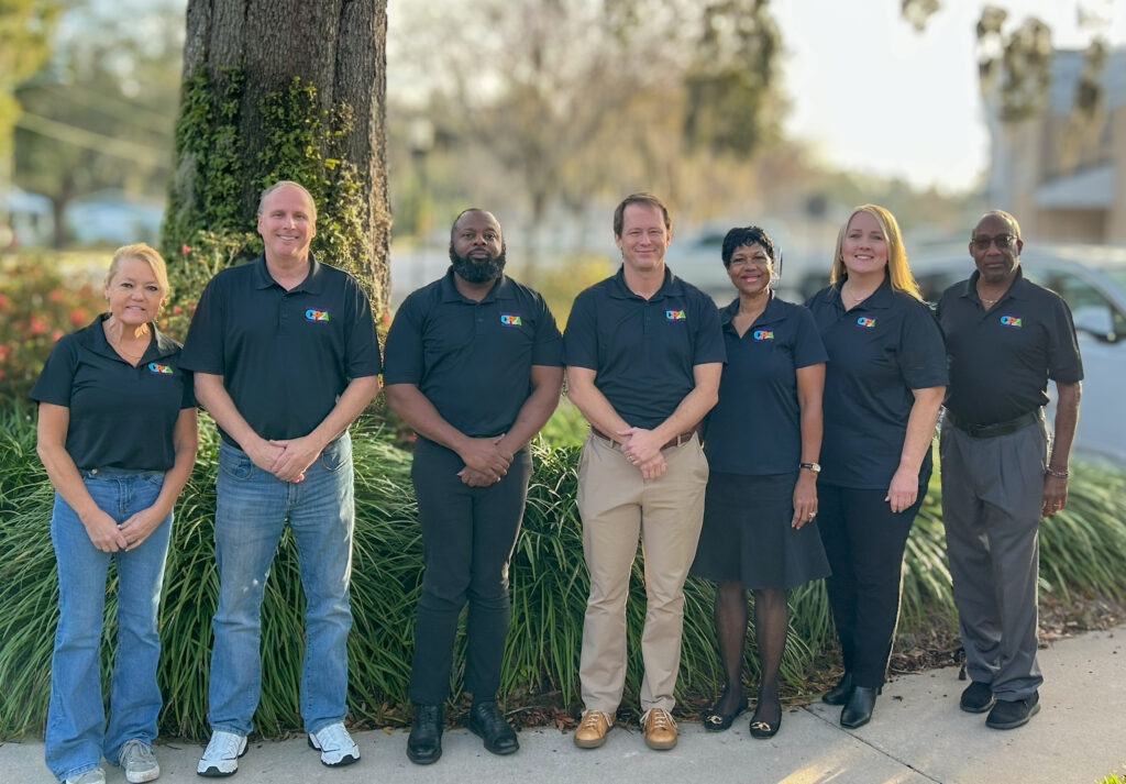 Bartow CRA board members in CRA polo shirts standing together outdoors