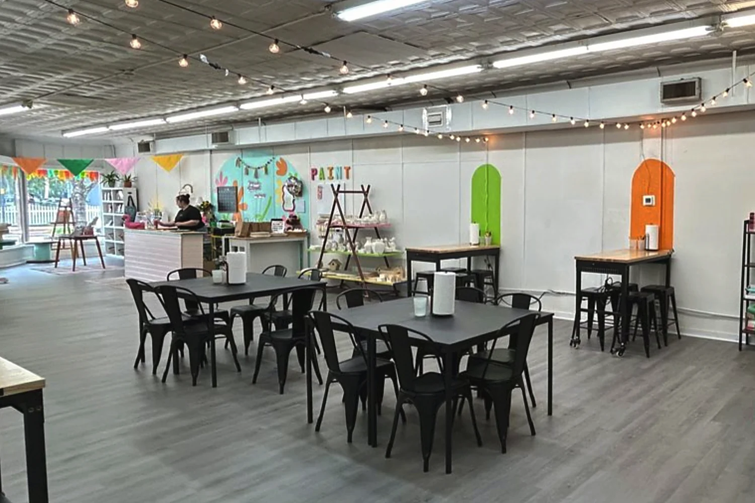 The same storefront after the Commercial Enhancement Grant, now an open paint studio with seating and retail display